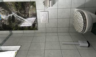 A small bathroom with a toilet and tiled walls. On the wall hangs a picture of a waterfall.