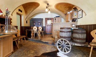 A cozy room with a rustic flair, featuring wooden furniture and decorations made from barrels. The area is bright and inviting, perfect for social gatherings.