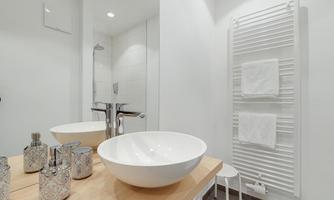 A modern bathroom with a stylish sink and elegant accessories. Bright walls and towels give the space a fresh atmosphere.