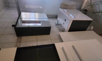 A modern bathroom with a sink and a mirrored cabinet. The walls are tiled and there is a shower cubicle.