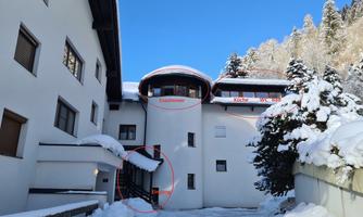 A modern building in the snow with a clear blue sky. The architecture is unique and well-designed.