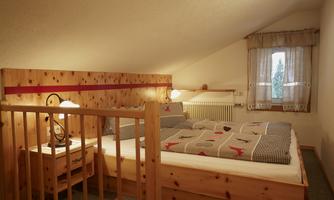 A cozy bedroom with a wooden bed and soft lighting. The room has a window overlooking the outdoors and a warm, inviting atmosphere.