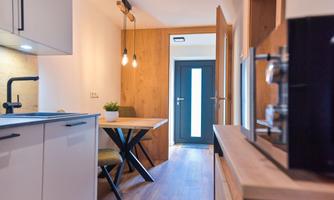A modern kitchenette with a dining table and chairs. The room has an inviting atmosphere with plenty of natural light.