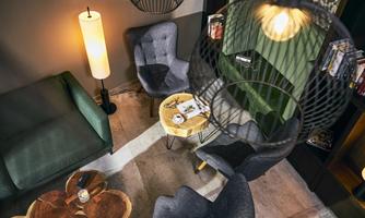 A modern living room with cozy chairs and a round table. The atmosphere is warm and inviting.