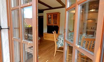 A bright and inviting apartment with wooden windows. The view shows a cozy dining area with a beautiful floor.