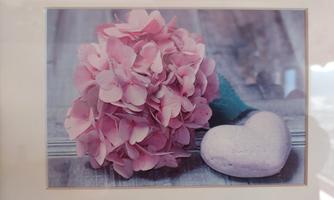 A beautiful bouquet of pink hydrangeas next to a heart-shaped stone object. The soft colors and natural arrangement create a calming atmosphere.