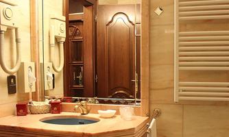 An elegant bathroom with wood details and a stylish vanity top. There is a mirror, a towel radiator, and a decorative bowl on the sink.