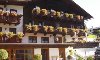 A cozy building with several balconies adorned with colorful flowers. The facade is bright and invites you to linger.
