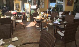 A cozy restaurant with a bright, inviting atmosphere. The tables are lovingly set and surrounded by stylish decorations.