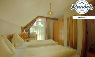 A cozy bedroom with two beds and a warm, inviting atmosphere. Large windows provide plenty of daylight and a view outside.