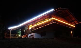 A cozy holiday home, illuminated at night. It offers an inviting atmosphere in nature.