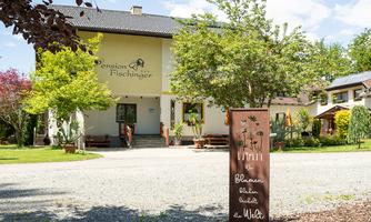 A guesthouse surrounded by trees and green spaces. The entrance is welcoming and invites you to linger.