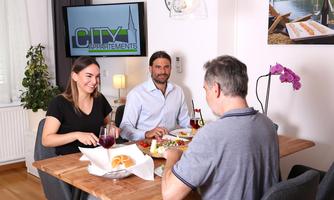 A cozy dining room with three people enjoying a meal together. Delicious food and drinks are on the table.