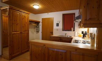 A cozy kitchen with wooden furniture and a cooking area. The rooms are bright and inviting.