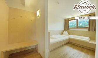A bright, modernly designed room with a simple bed and a small table. Large windows provide a beautiful view of the landscape.