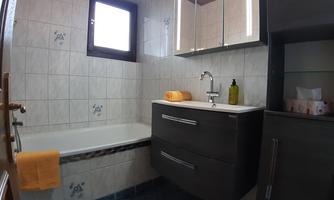 A modern bathroom with a bathtub and a sink. Towels included.