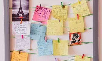 A positive memory board with colorful notes and pictures. The notes are attached to a frame with clips.
