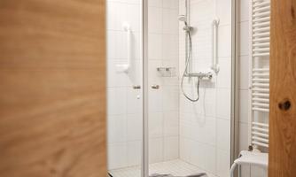 A modern shower with a glass partition and bright tiles. The space looks clean and inviting.
