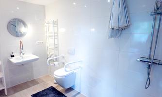Bright, age-appropriate bathroom with walk-in shower, toilet with grab bars, and plenty of space to move. Here you can start your day relaxed, and there is enough room even with children or when comfort is important.