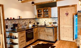 A modern kitchen with wooden elements and colorful tiles. The decor is cozy and inviting.