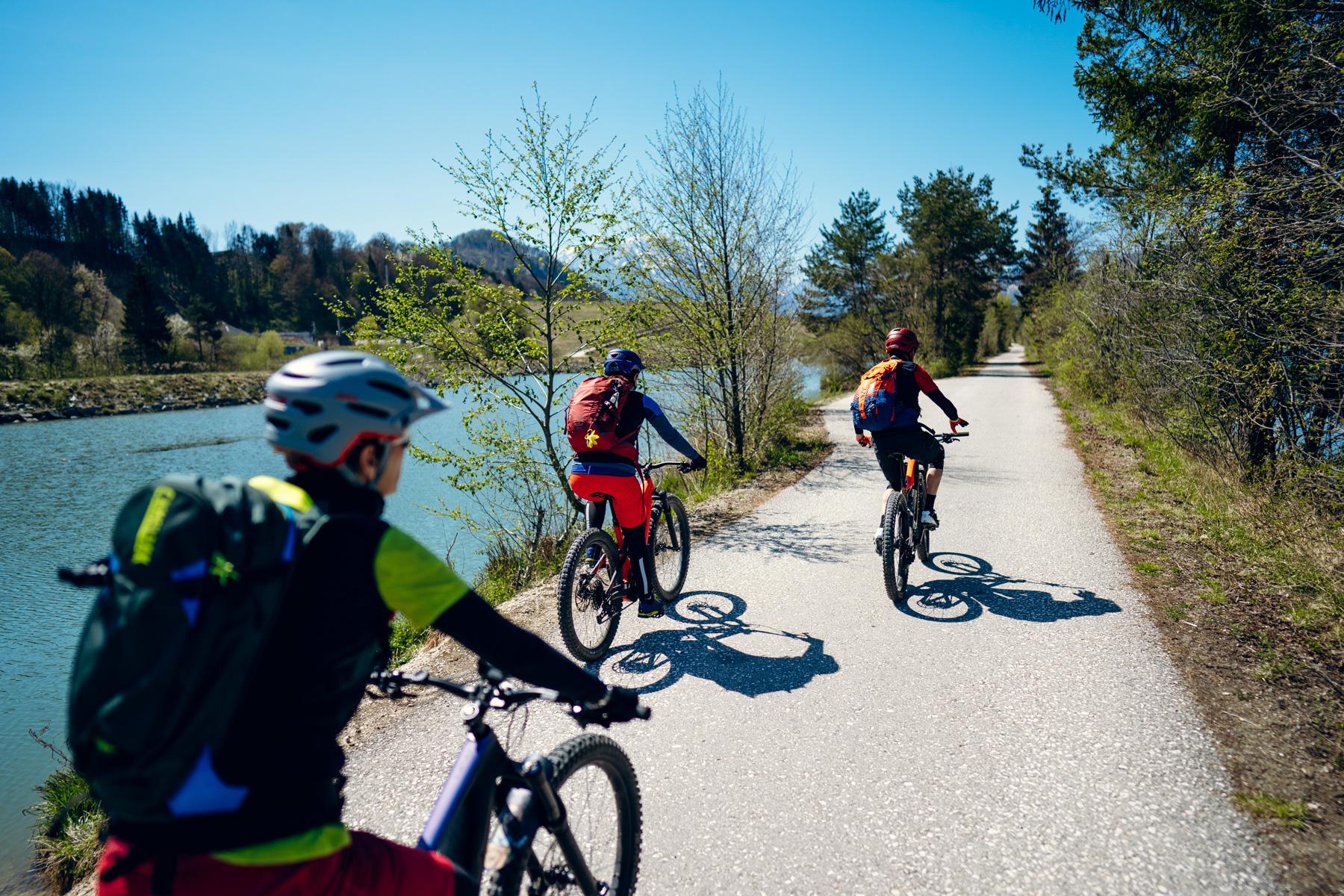 Mountainbiker fahren auf einem Radweg entlang eines Flusses in Österreich