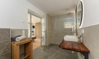 A modern bathroom with tiled floor and an elegant sink. The atmosphere feels bright and inviting.