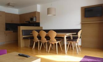 A modern kitchen with a dining table and chairs. Bright wooden furniture and a cozy atmosphere.