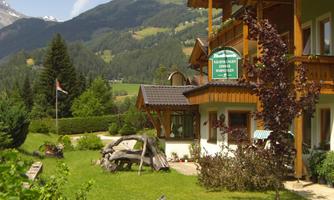 A cozy residence with a well-kept garden and a view of the mountains. The surroundings are green and inviting.