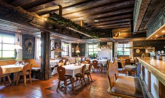 A rustic restaurant with wooden beams and tables. The cozy atmosphere invites you to linger.