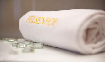 A towel with the inscription "FELSENHUBE" lies on a surface. Next to it are some small glass marbles.