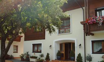 A cozy house with an inviting entrance. The garden is beautifully decorated with flowers and plants.