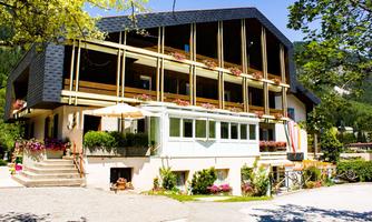 A charming building with balconies and colorful flowers. The relaxed atmosphere is accentuated by the surrounding nature.