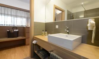 A modern bathroom with an elegant sink and wooden shelves. The atmosphere is bright and inviting.