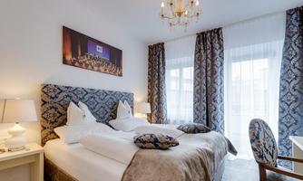 A stylish bedroom with a cozy double bed and elegant curtains. The room features a modern chandelier and harmonious decoration.
