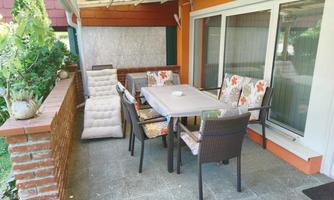 A cozy outdoor area with a table and chairs. The surroundings are green and inviting.
