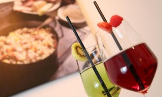 Two colorful cocktails in glasses, one green with kiwi and one red with raspberry. In the background, there is a plate with a dish visible.