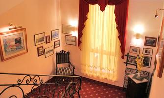 A bright staircase with red curtains and historical pictures on the walls. The atmosphere is welcoming and cozy.