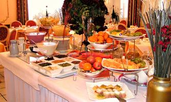 A lavish buffet with a selection of fresh fruits, desserts, and vegetables. The table is elegantly set and invites you to indulge.