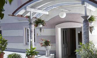 An inviting entrance to a building with plants and a distinctive canopy. The walls are designed in soft colors.