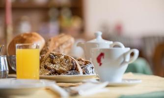 A hearty breakfast with fresh pastries, a cup of coffee, and a glass of orange juice. The table is set in a welcoming manner and invites you to indulge.