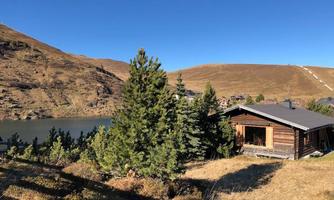 The alpine hut is located in a secluded location and yet is protected by pine trees.