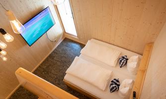 The bedroom and a cozy sleeping alcove with a panoramic window on the upper floor offer space for up to four people. The beds will be made up for you upon arrival.