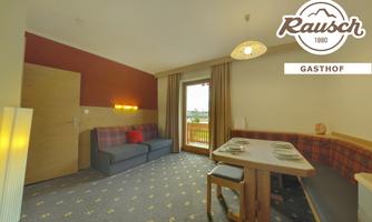 A cozy room with a sofa and a table. Bright colors and large windows create a friendly atmosphere.