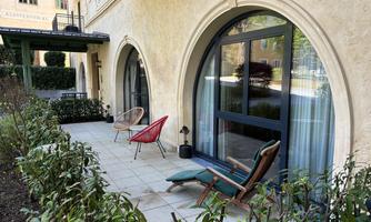 A cozy terrace with modern chairs and a view of the garden. The surroundings are quiet and inviting.