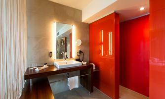 A modern bathroom with a large sink and a illuminated mirror. The walls are designed in warm colors, creating an inviting atmosphere.