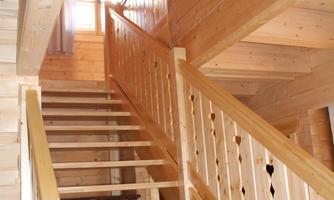 A bright wooden staircase in a cozy room. The stairwell has a warm, inviting atmosphere.