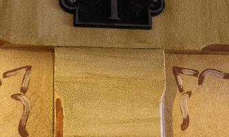 A door with the number "1" in black color. The background is made of golden material and displays some ornate decorations.