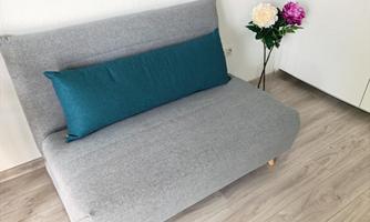 Modern sofa bed in the living area – ideal for relaxing during the day and as an additional sleeping option when needed.