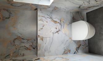 A modern bathroom with elegant marble wall design. The toilet is simply and contemporarily integrated.