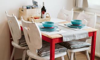 A cozy dining area with a table and four chairs. The table is carefully set and the surroundings feel inviting.